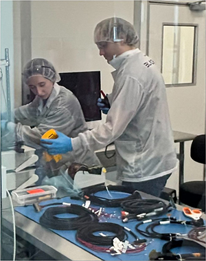 Image of cleanroom with 2 lab workers and equipment