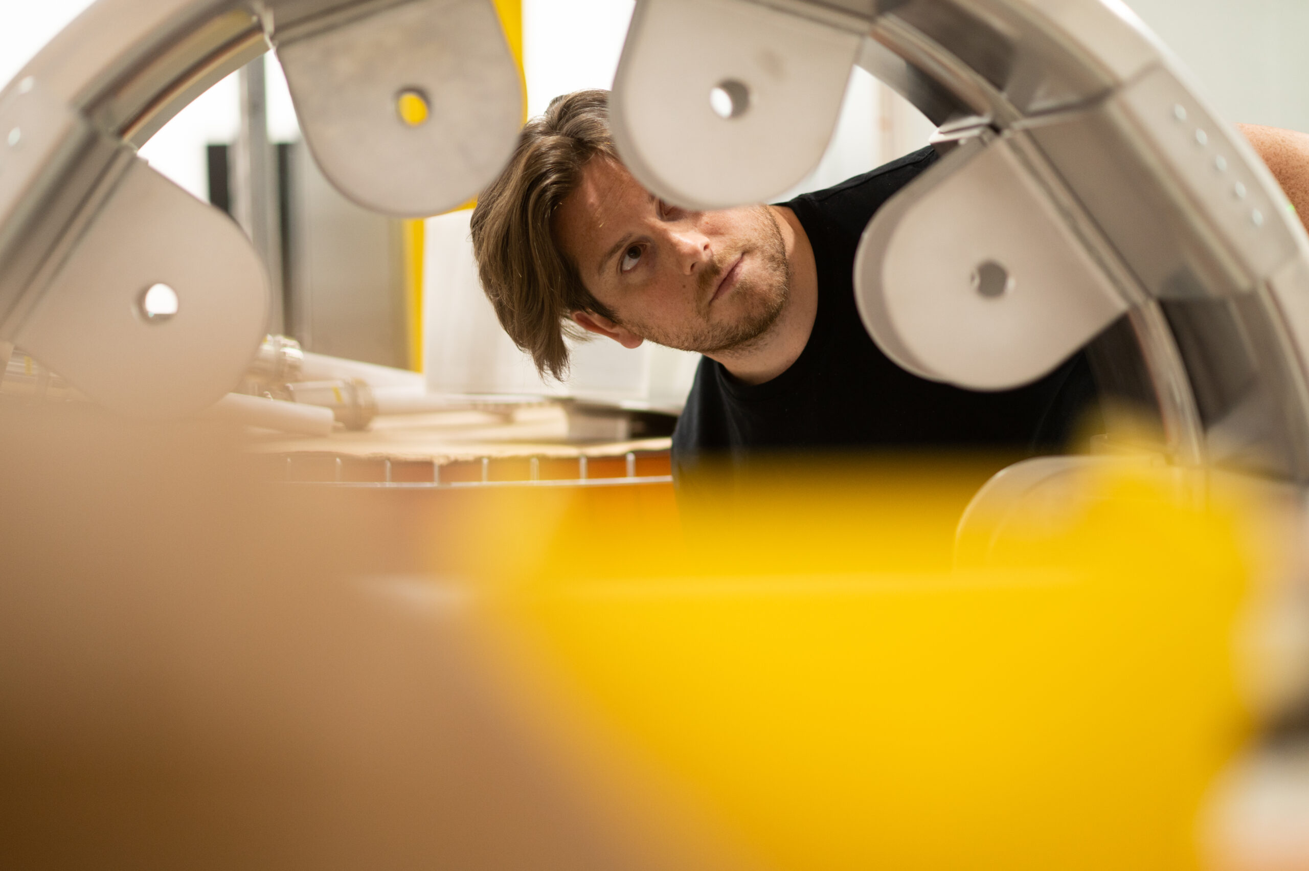 Man peers through a fusion module which appears to be a large gear-like structure.
